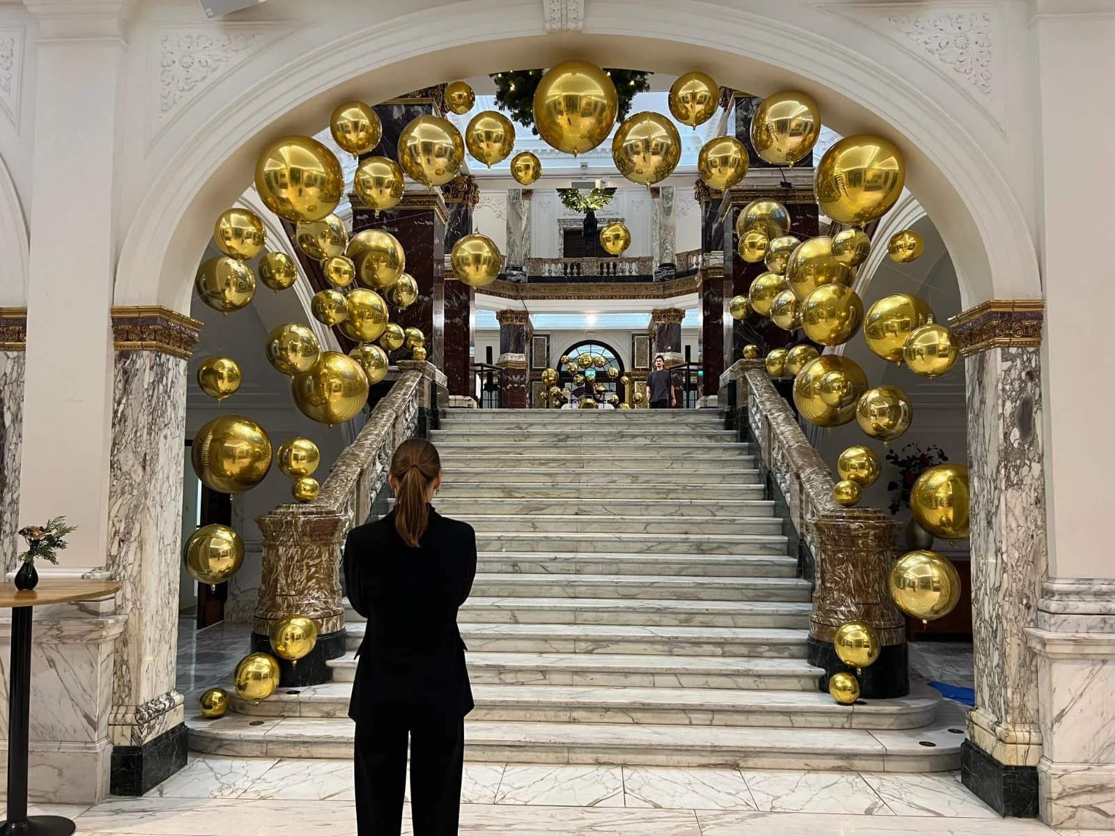 Gold balloons cascading down a marble staircase for a luxury brand activation